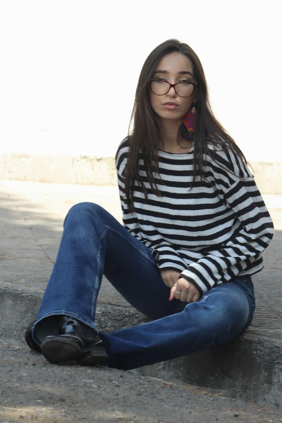 Seated portrait in striped top and denim